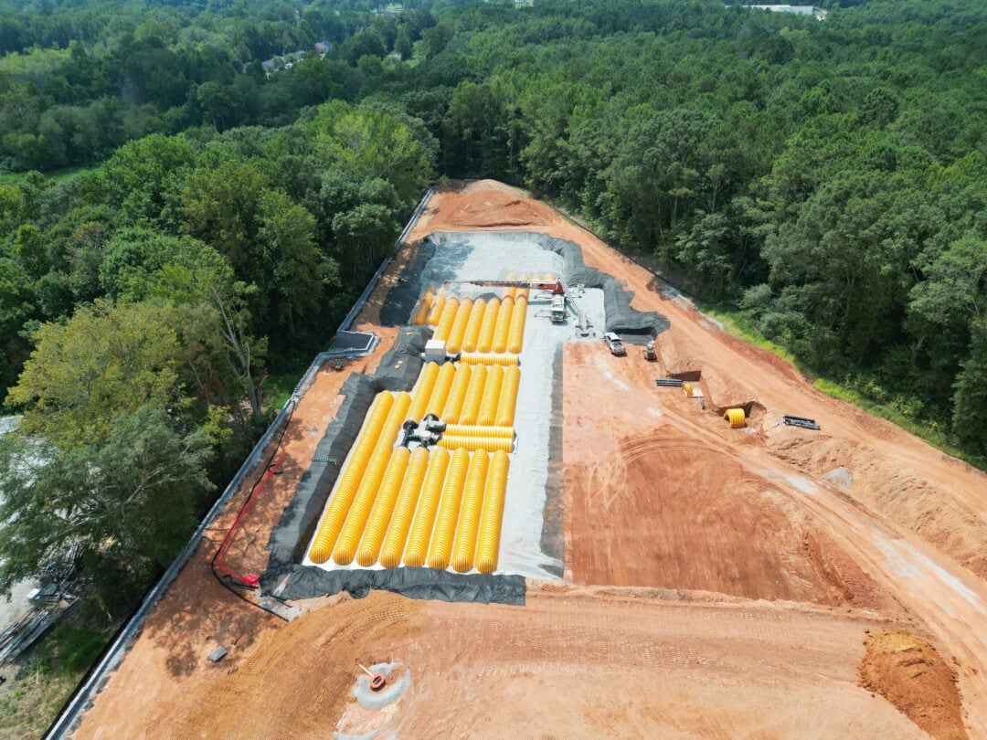 Aerial view of construction site with yellow pipes.