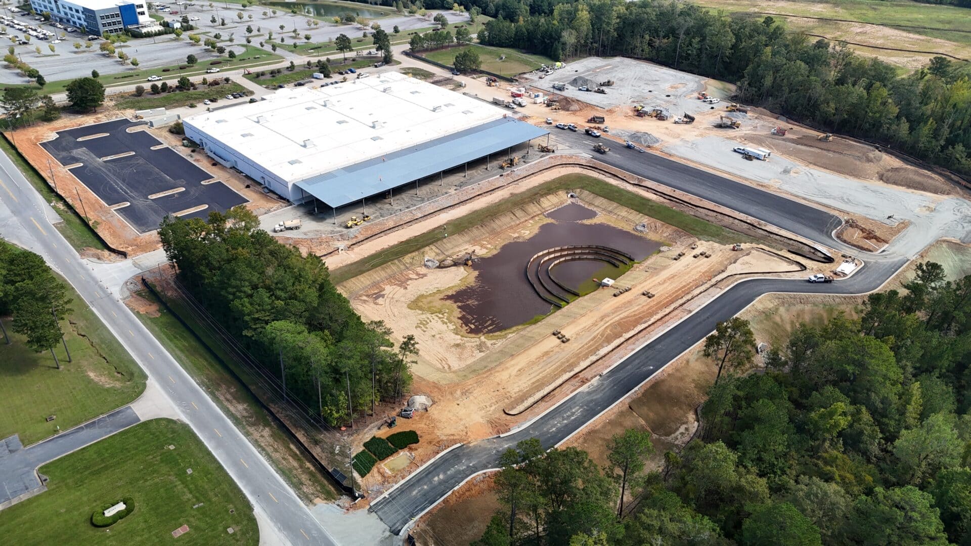 Project Northstar Aerial view of construction site with building and pond.