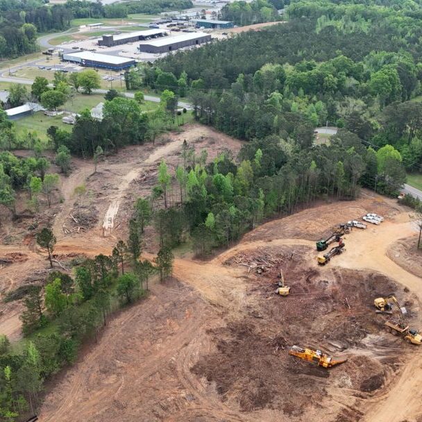 Aerial View of Site Clearing and Forest Area Aerial view of partial site clearing next to a forest with nearby industrial buildings