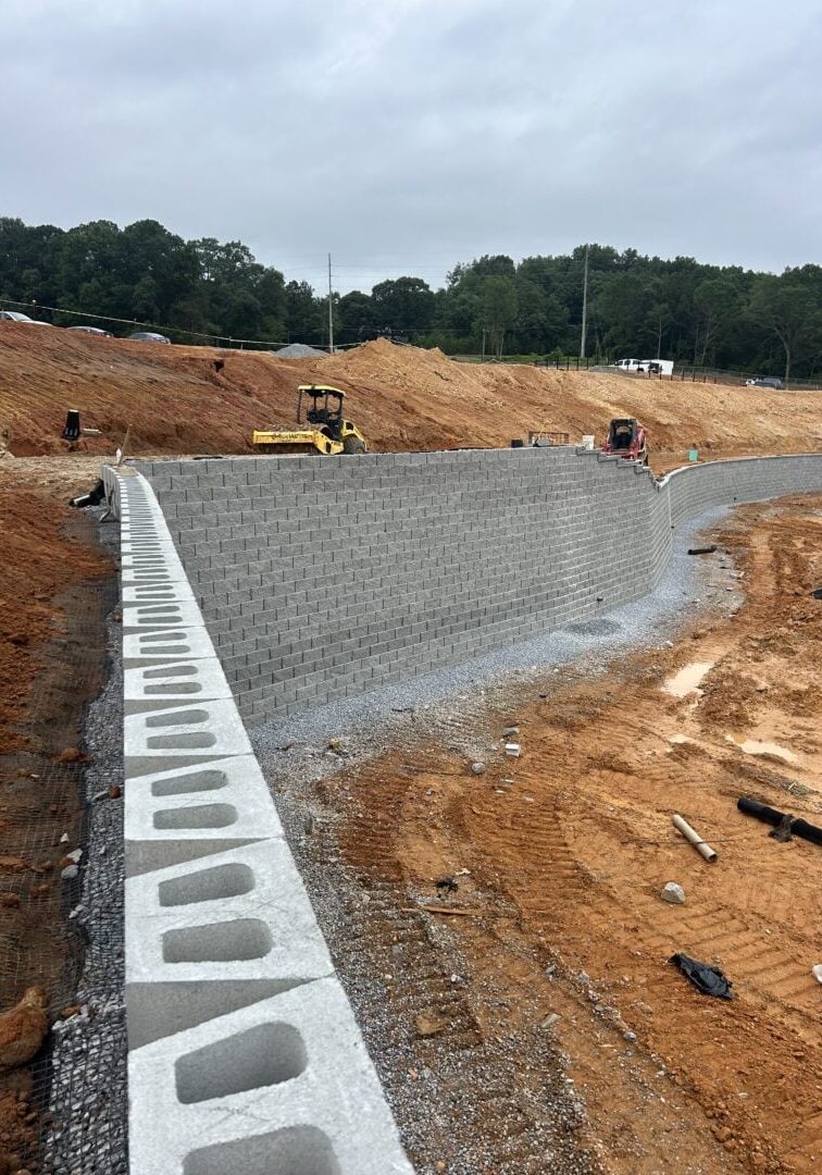Retaining Wall Construction at Graded Site Concrete block retaining wall under construction at a large graded site