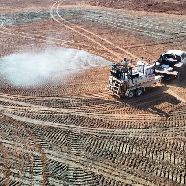 Water Truck Spraying Graded Construction Site Water truck spraying dust control on freshly graded dirt construction site