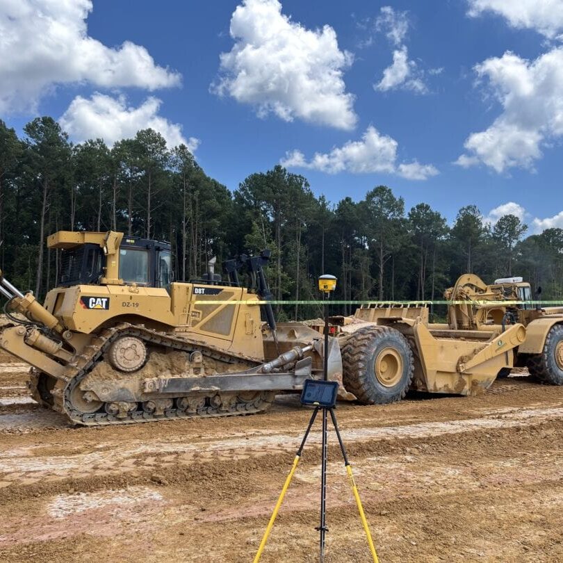 Bulldozer and Scraper with Survey Equipment CAT bulldozer and scraper parked with GPS survey equipment on construction site