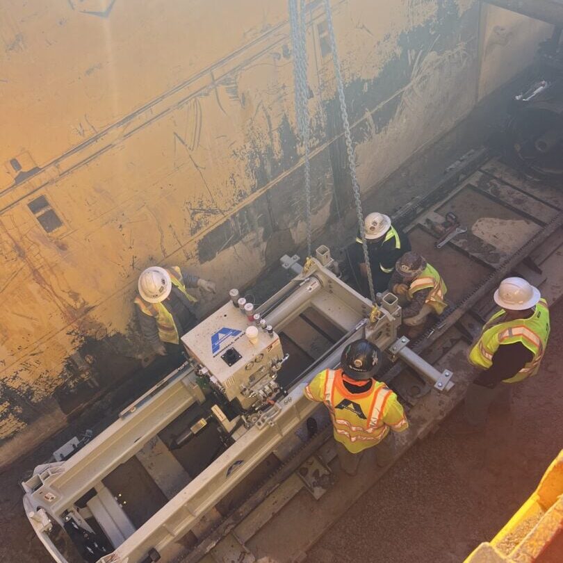 Workers Assembling Boring Machine Inside Trench Box Construction workers assembling boring machine inside trench box for pipeline installation