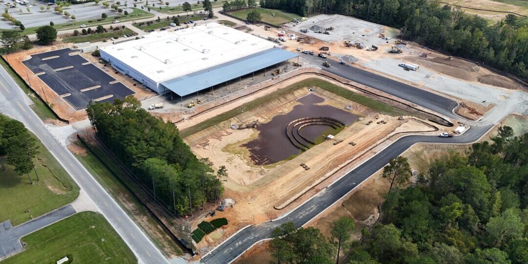 Project Northstar Aerial view of construction site with building and pond.